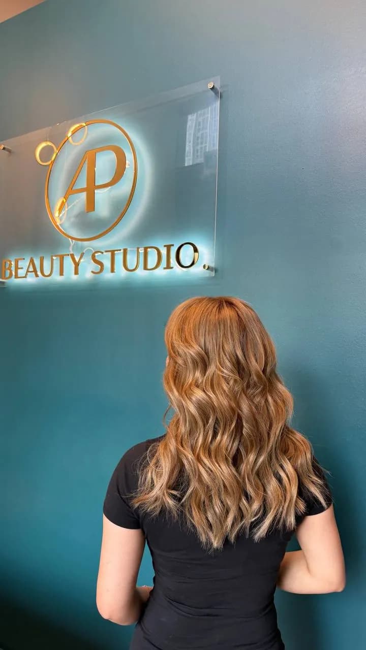 Warm copper waves in front of the AP Beauty Studio sign