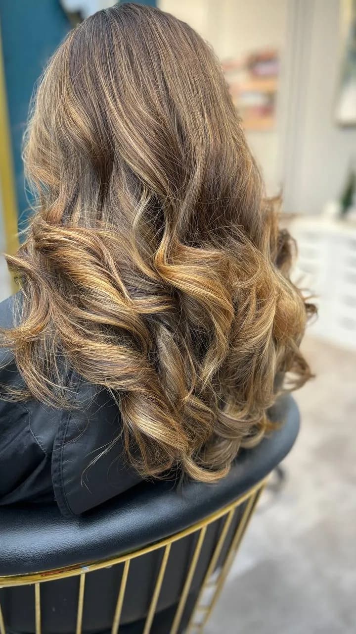 Golden balayage styled in soft curls